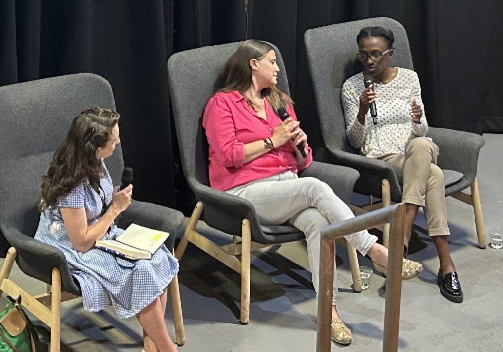 Three women sitting on chairs speaking at a panel event called Startup Stories: Spinout Edition